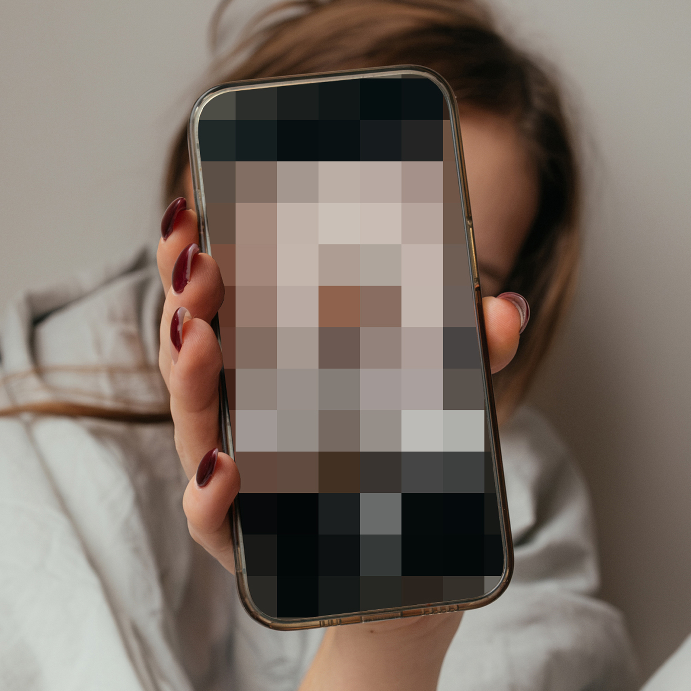 Child holding phone with pixelated image