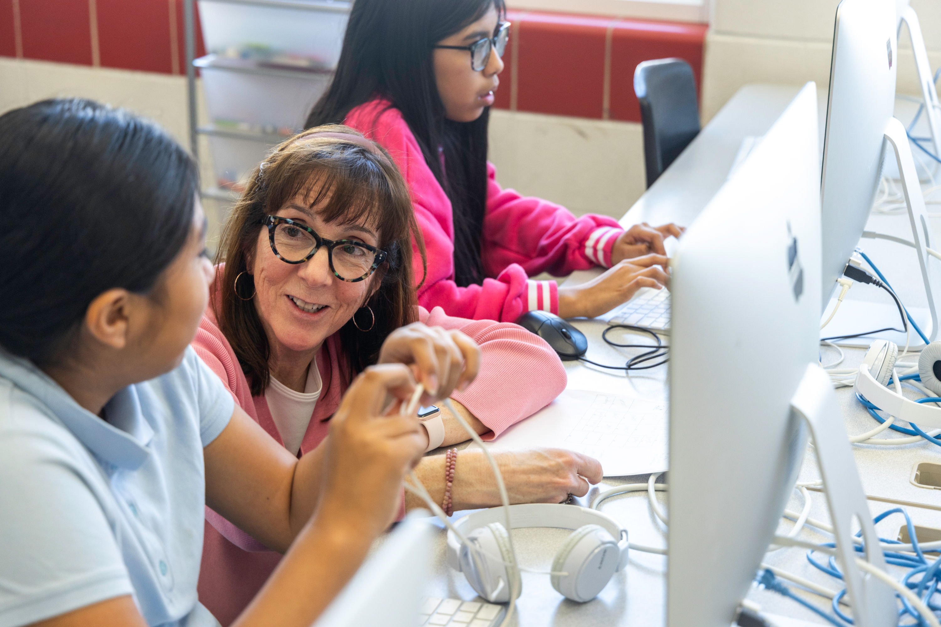 A teacher and two students at a computer