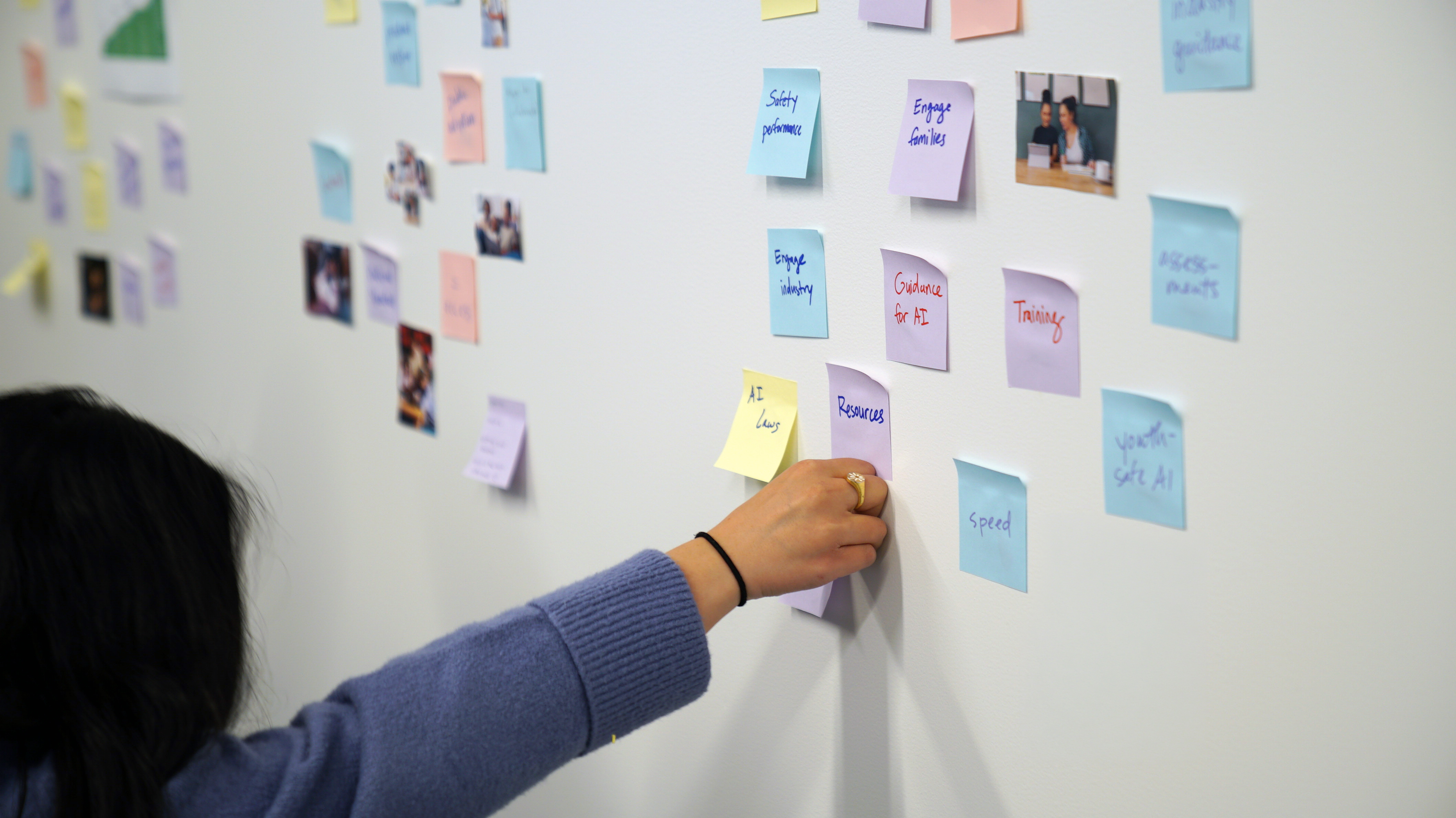 Post-it notes related to youth AI safety on a wall